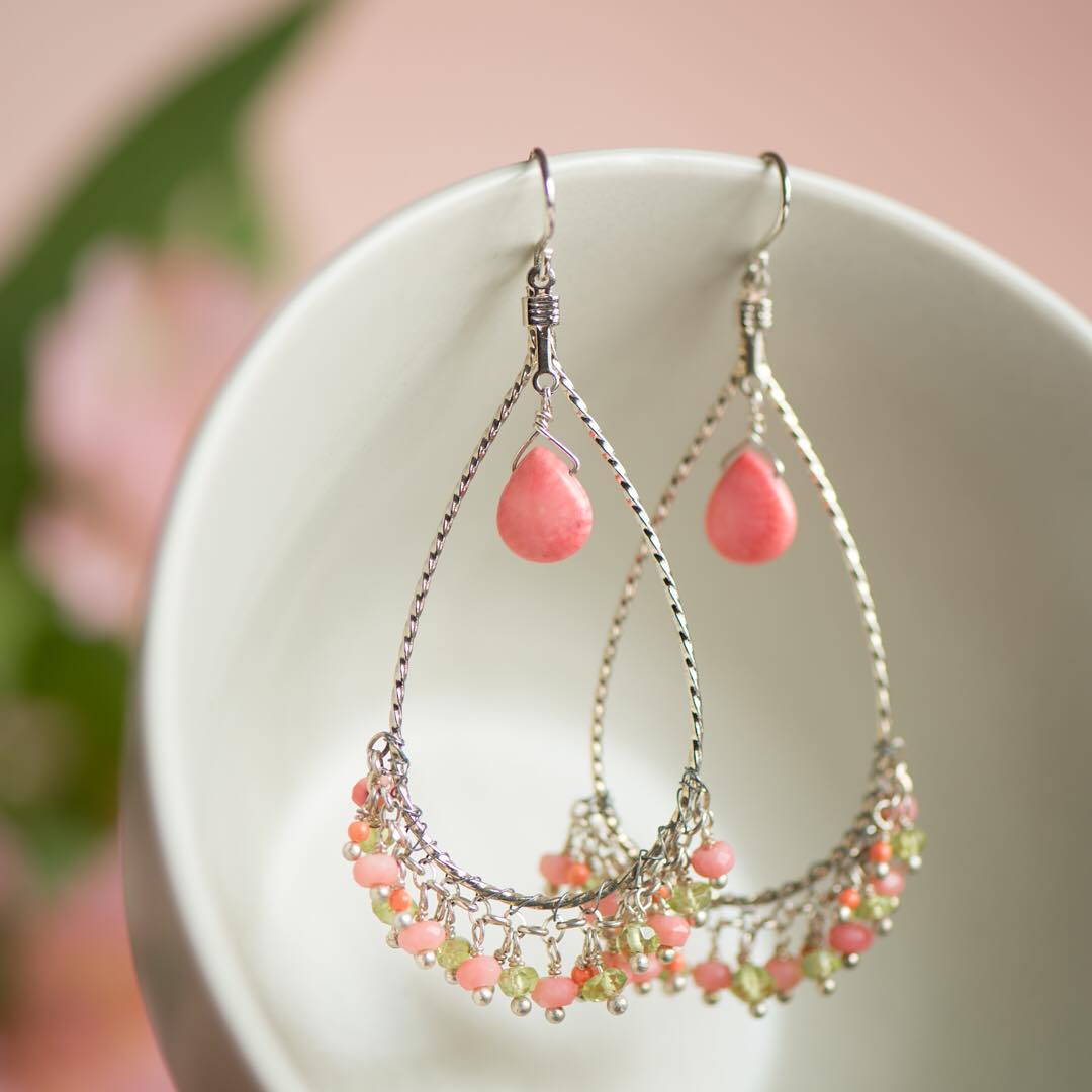 Pretty, statement earrings - the twirled silver frames are fringed with coral and peridot.