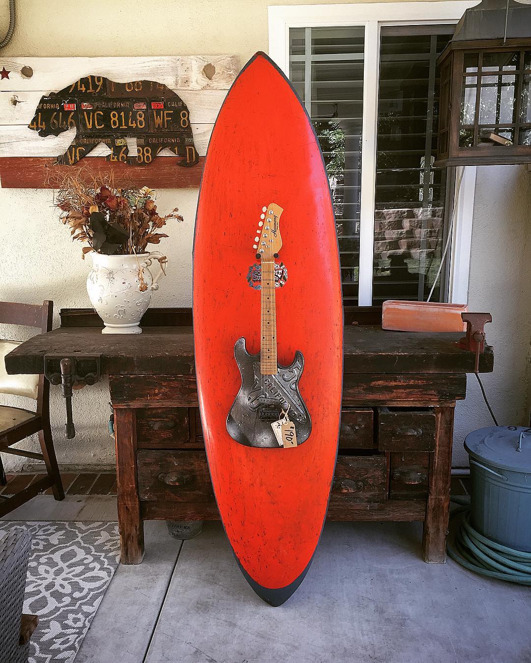 Removable working electric guitar mounted on a vintage surfboard makes a great wall hanger for the beach-house