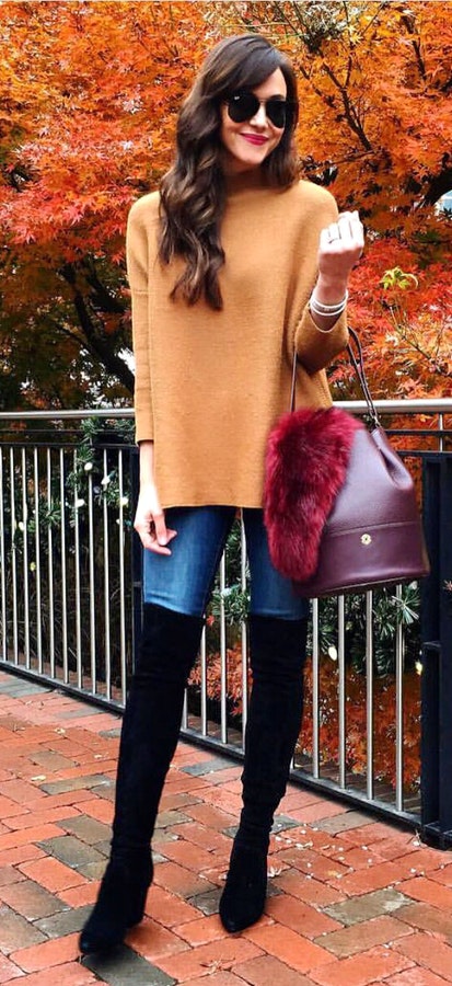 Women's brown crew-neck long-sleeved shirt and blue skinny jeans.
