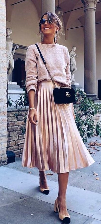 Women's brown turtle neck sweater and brown midi skirt.