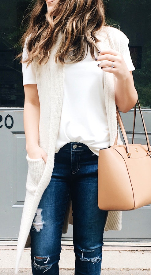 Women's white t-shirt with white cardigan and blue denim jeans outfit.