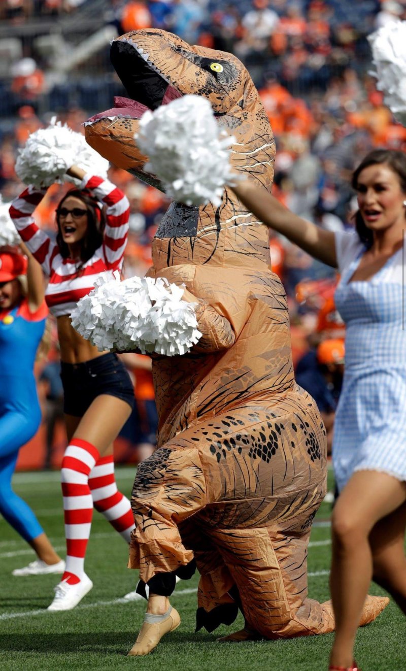 Broncos cheerleader chooses T-Rex costume for Halloween game.