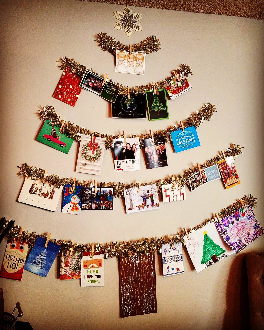 Display holiday cards by clipping them to a DIY tin garland Xmas tree.