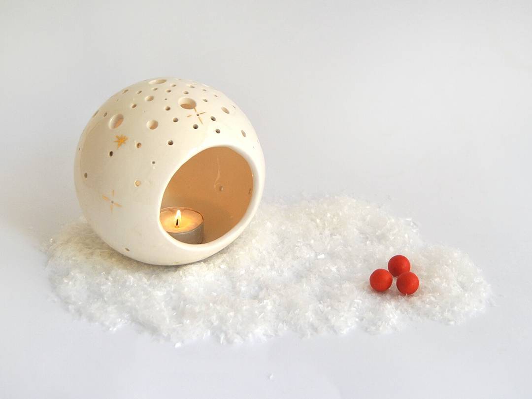 Spherical candleholder with gold star.