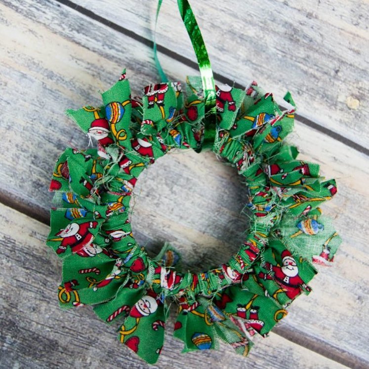 This simple mason jar lid Christmas wreath ornaments take minutes to make and can be customized with any color fabric.
