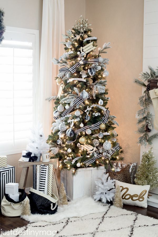 Black-and-white striped ribbon wraps around a Christmas tree