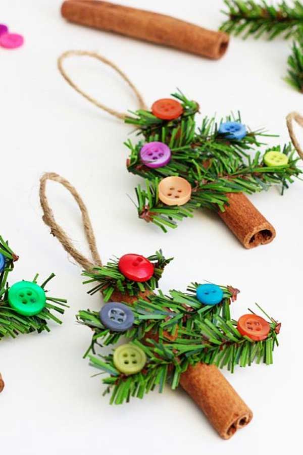 Christmas tree ornaments made with pine leaves, cinnamon sticks and buttons.
