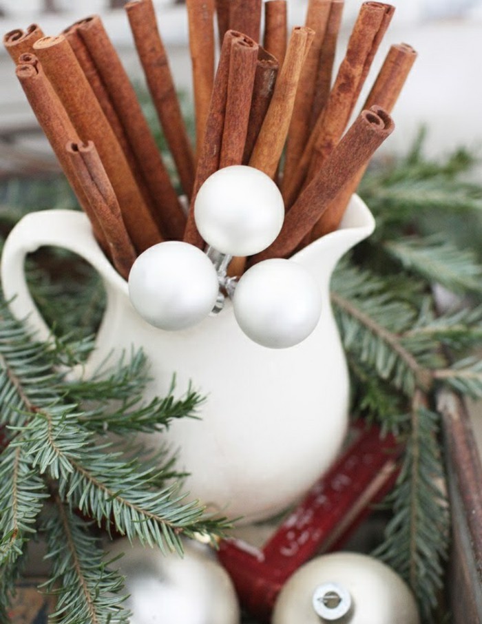 Long cinnamon sticks in a white jar.